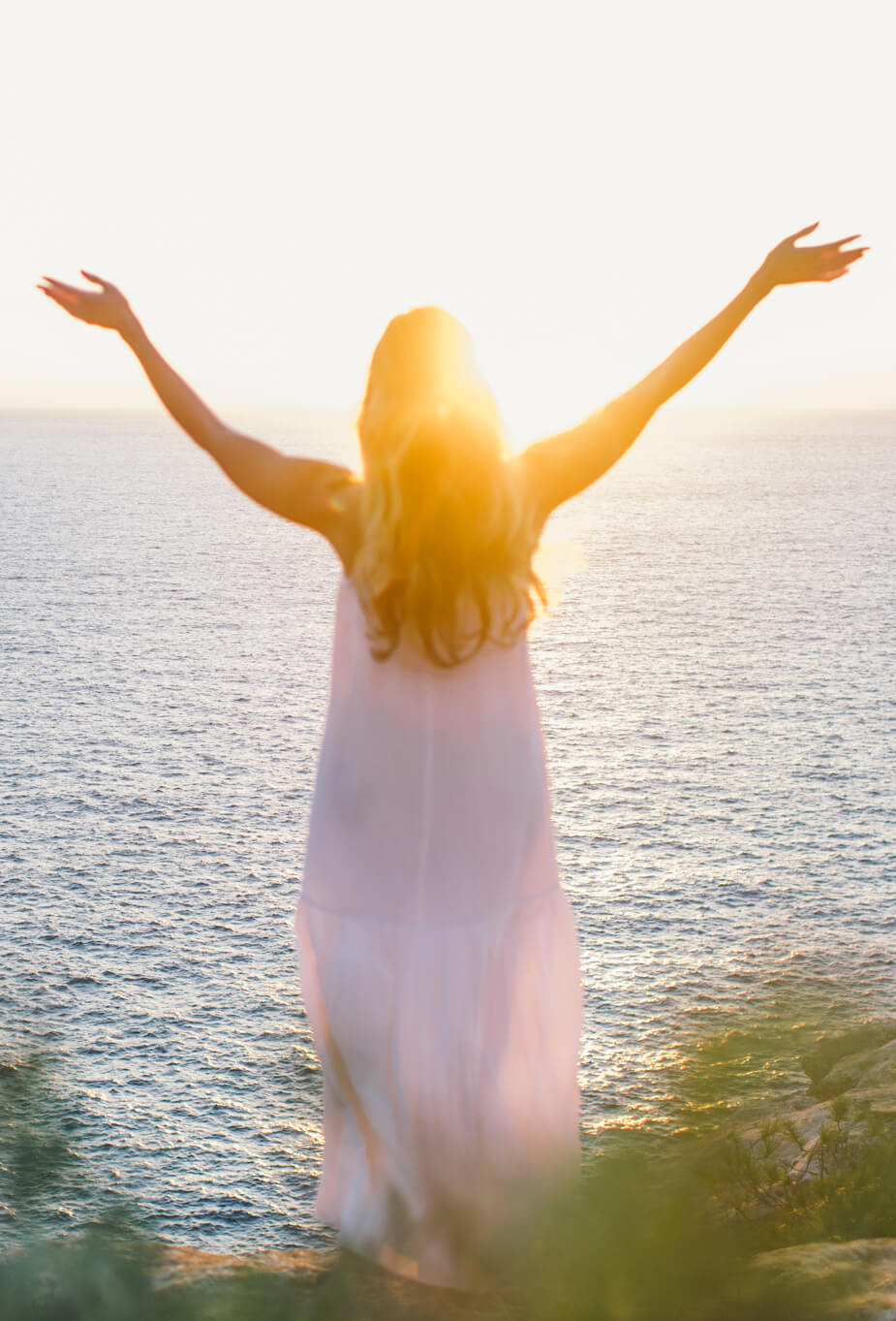 Femme levant les bras au soleil